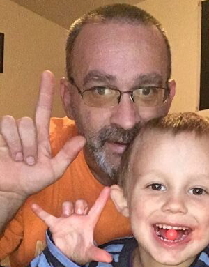 a man and a child holding up the ASL sign for 