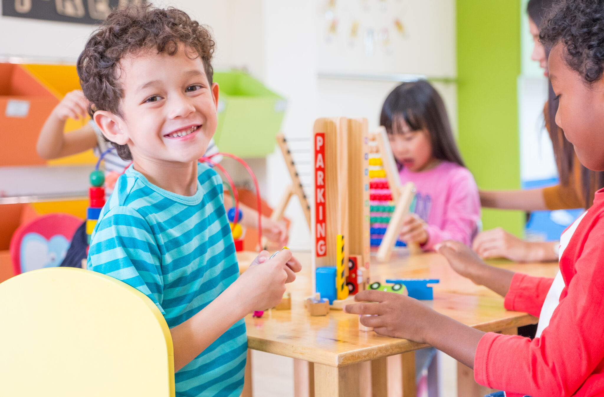 Kindergarten students smile when playing toy in playroom at preschool international,education concept